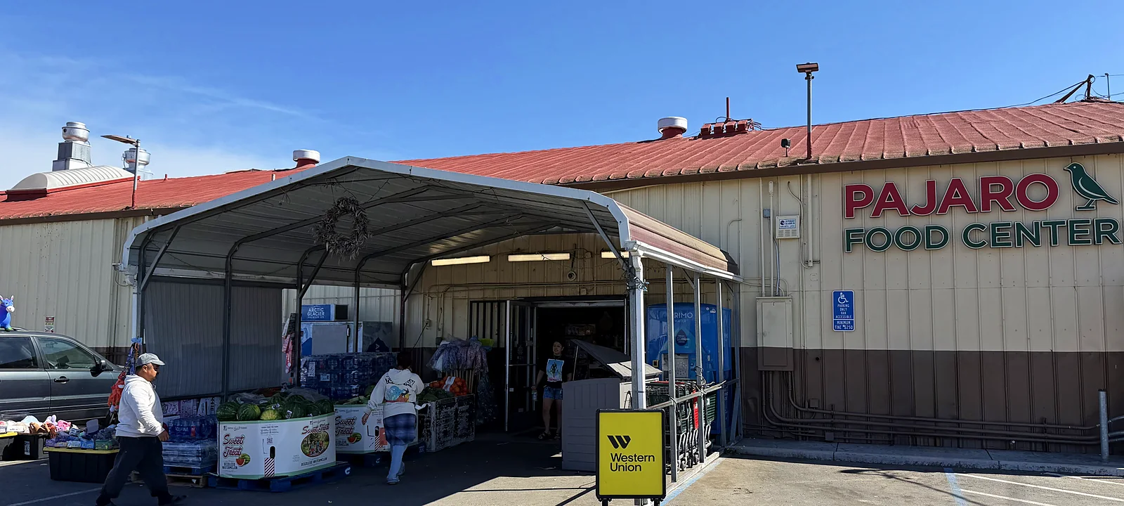 La fachada de Pajaro Food Center sobre Salinas Road: el letrero rojo y verde con el pájaro y el toldo de la entrada