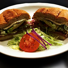 Una torta en bolillo con jamón, aguacate, lechuga, jitomate y jalapeño